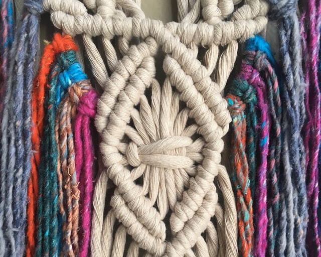 macrame piece with pink, blue and beige string