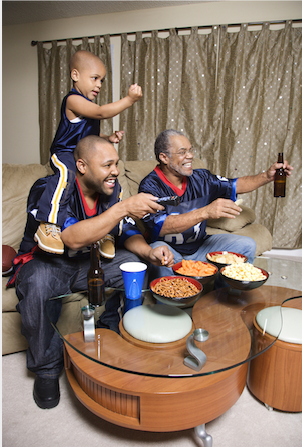 3 generations of family snacking watching tv