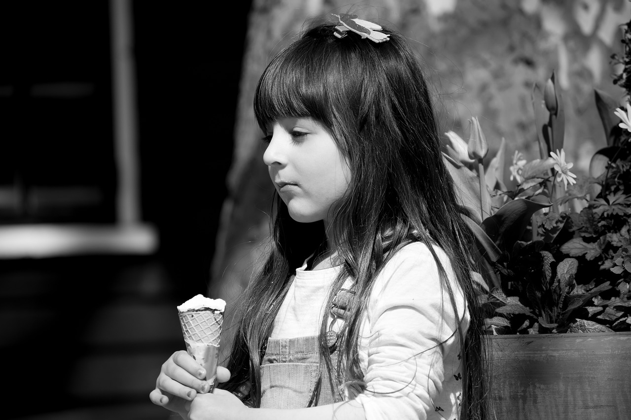 black and white photo of pensive child with ice cream 