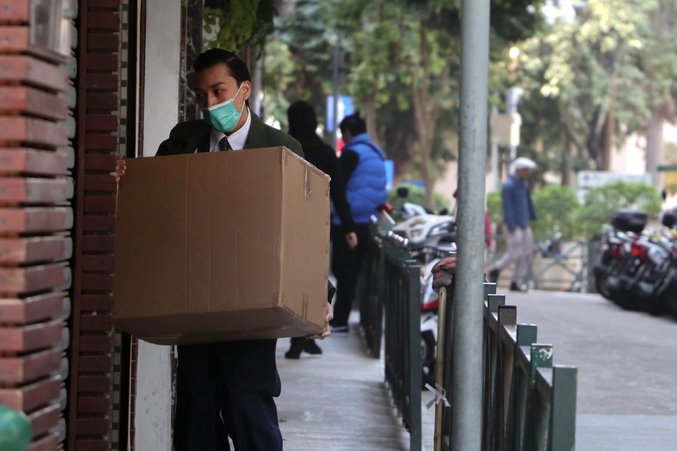 man in covid mask delivering box